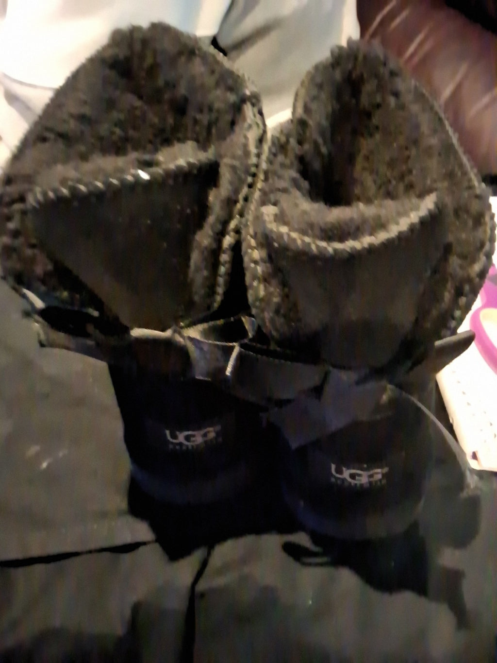 These black UGG Bailey Bow II boots feature a suede upper and a fixed satin bow